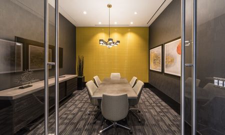 Conference room at our apartments in Arlington, featuring carpeted flooring and a conference table with chairs.