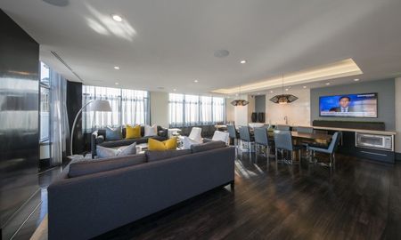 Resident lounge and dining area at our Arlington apartments, featuring wood grain floor paneling and ample seating.
