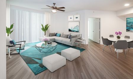 Model living room at our apartments in Pompano Beach, FL, featuring a grey couch, wood laminate floors, and modern decor.