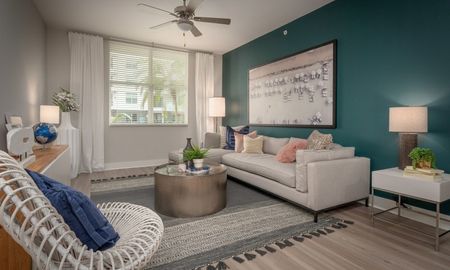 Model living room at our apartments for rent in Pompano Beach, FL, featuring wood grain floor paneling.