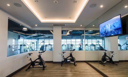 The fitness center at our apartments in Miami, featuring spin bikes facing a TV and a view of the work out room & gym