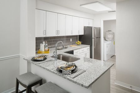 Model kitchen at our apartments in Tampa, featuring granite countertops and stainless steel appliances.