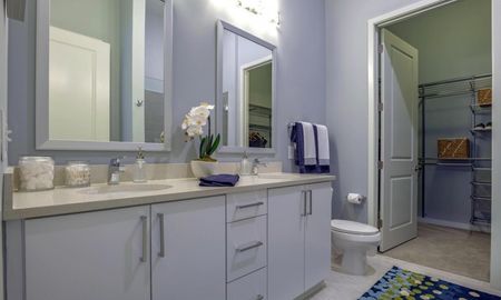 Model bathroom at our apartments for rent in Sandy Springs, featuring lavender walls and a view of the walk in closet.
