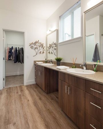 Interior view of a bathroom with dark wood cabinetry inside a luxury apartment near Seattle.
