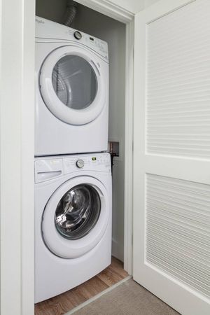 In unit washer and dryer at our apartments in Kenmore, featuring a vertical washer dryer in a closet.