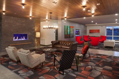 Community lounge with multiple seating areas and a fireplace inside Spencer 68 apartments near Kirkland WA.