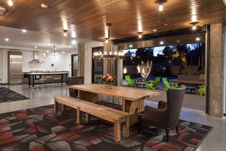 Community dining space with rustic wood dining table inside Spencer 68 apartments in Kenmore Washington.