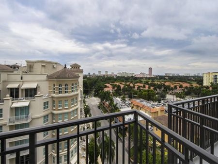 Photograph taken from the balcony of one of our apartments in Boca Raton, featuring metal railings and a view of the city.