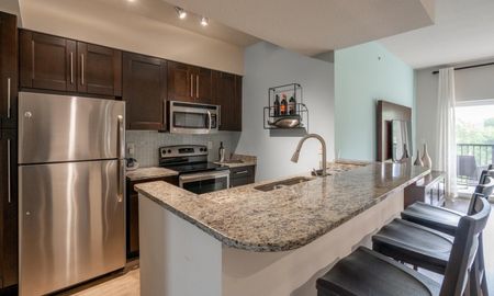 Kitchen island with a granite countertop inside a luxury Delray Beach apartment.