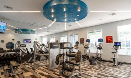 Various exercise machines inside a Delray Beach apartment gym.