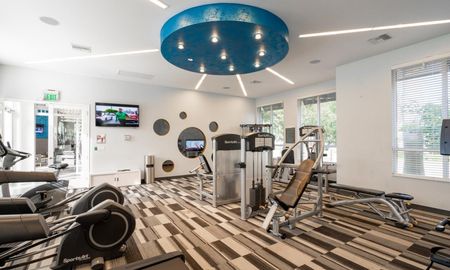 Various exercise machines inside a luxury Delray Beach apartment gym.
