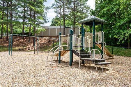 The playground at our apartments for rent in Mooresville, NC, featuring wood chips and a play structure.