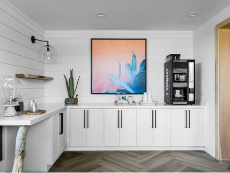 Common kitchen at our apartments in Pompano Beach, FL, featuring a coffee machine, white cupboards, and colorful decor.