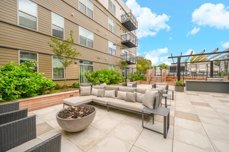 Outdoor lounge at our apartments for rent in Watertown, MA, featuring outdoor couches and a fire pit.