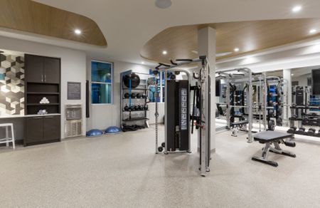 The fitness center at our apartments for rent in Watertown, MA, featuring free weights and exercise machines.