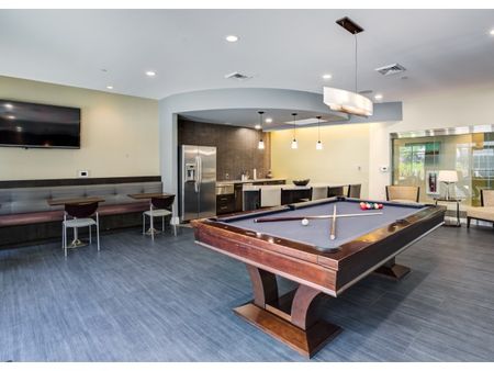 A sleek resident lounge with a community kitchen and pool table at Everly apartments, located near Reading MA.