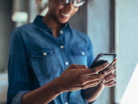 woman holding phone viewing a self-guided tour