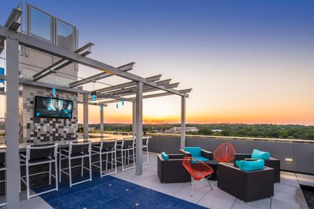 rooftopOutdoor lounge at our apartments for rent in Arlington, featuring outdoor couches, a TV, and string lights.