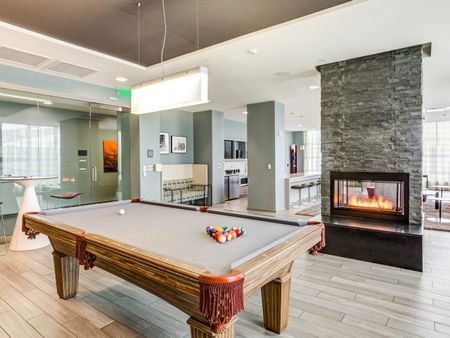 Cambridge apartments resident lounge with a fireplace and pool table.