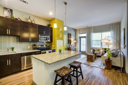 An interior view of a luxury Wakefield apartment kitchen with a gorgeous kitchen island and a view of the living space.