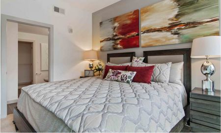 Model bedroom at our apartments for rent in Atlanta, GA, featuring white bedspread and elegant decor.