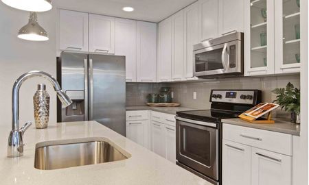 Model kitchen at our apartments in Atlanta, featuring white countertops and stainless steel appliances.