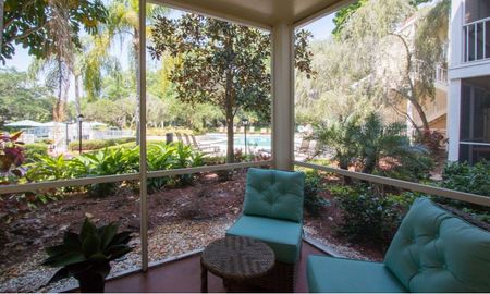 Glass patio space with seating at a Clearwater apartment.