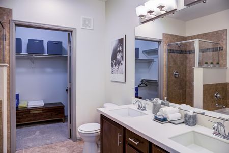 Luxury Denver apartment bathroom with tiled flooring and dark cabinetry.