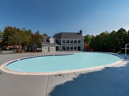 The pool area at our apartments for rent in Germantown, MD, featuring a 5 ft deep pool and a view of the club house.
