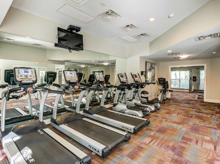Resident fitness center with treadmills and large mirror.