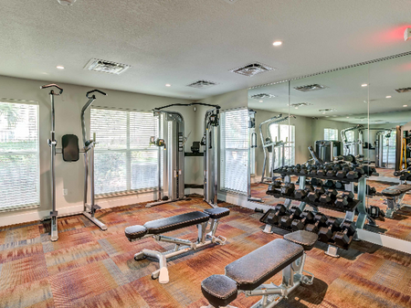 Fitness center with weights and large mirrors.