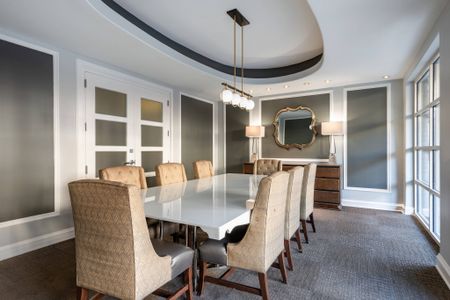 Conference room at our apartments in Alexandria, featuring a long conference table and ornate chairs surrounding it.