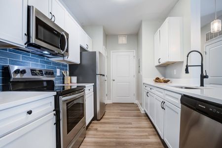 Model kitchen at our apartments for rent in Mooresville, featuring stainless steel appliances and white cabinetry.