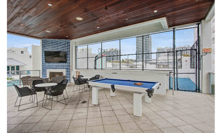 An outdoor patio with a pool table outside apartments near Miami Beach.