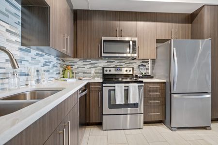 Model kitchen at our apartments for rent in Boca Raton, featuring white countertops and stainless steel appliances.