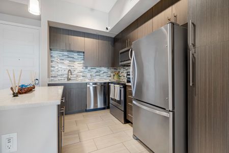 Model kitchen at our apartments for rent in Boca Raton, featuring white countertops and stainless steel appliances.