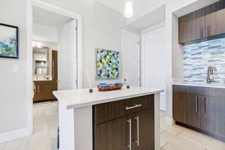 Model kitchen and dining room at our apartments in Boca Raton, featuring chairs around a table and counter seating.
