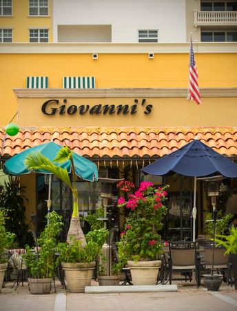 Giovanni's Italian restaurant near our apartments for rent in Boca Raton, featuring outdoor seating with umbrellas.