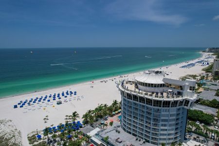 Aerial view of the beach near our apartments for rent in Clearwater, featuring the water and city high rises.