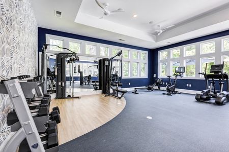 The fitness center at our apartments for rent in Mooresville, NC, featuring exercise equipment and free weights.