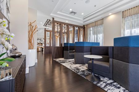 Lounge area at our apartments in Boca Raton, featuring wood grain floor paneling, couches, and large windows.