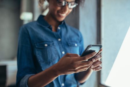 Woman smiling at her phone.