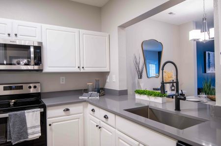Model kitchen at our apartments for rent in Owings Mills, MD, featuring grey countertops and stainless steel appliances.