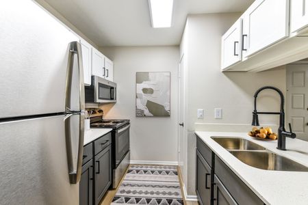 Renovated kitchen with white shaker cabinets and granite countertops.
