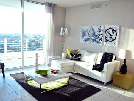 Brickell First Luxe City Rentals, interior, spacious living room, large sliding glass door, natural light, tile flooring, couch, coffee table, end table, lamps