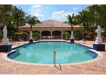Country Club Towers, exterior, sparkling blue pool, statues, palm trees, clubhouse