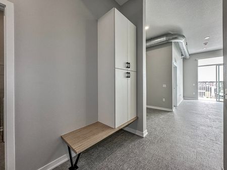 Storage and bench in entryway looking into living room at Level | Apartments in Des Moines, Iowa