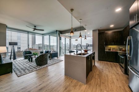 Kitchen with waterfall island and living room with floor to ceiling windows and downtown views