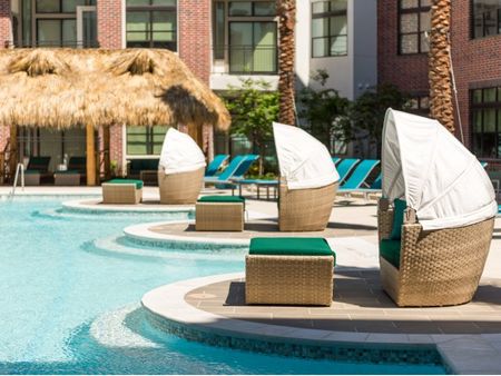 Shaded seating next to pool at Tinsley on the Park | Apartments In Houston