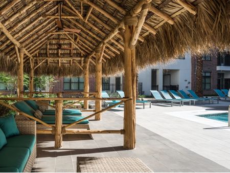 Outdoor grass-roofed shade for lounging near pool at Tinsley on the Park | Luxury Apartments Houston